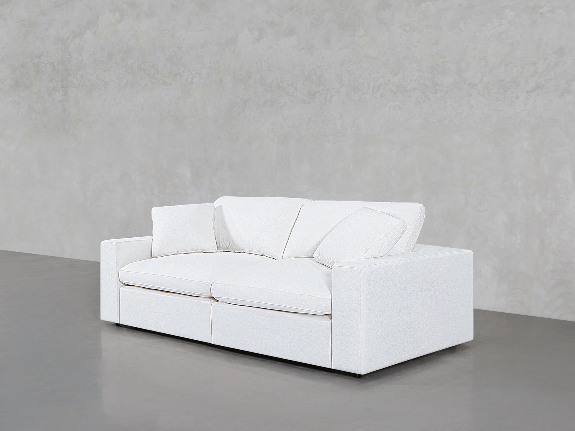 White loveseat with cushions angled to the left