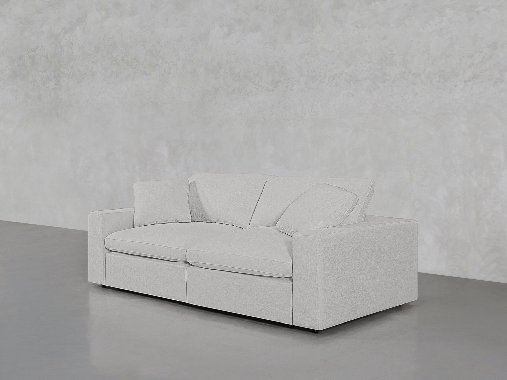 Orange-tinted white loveseat on grey floor