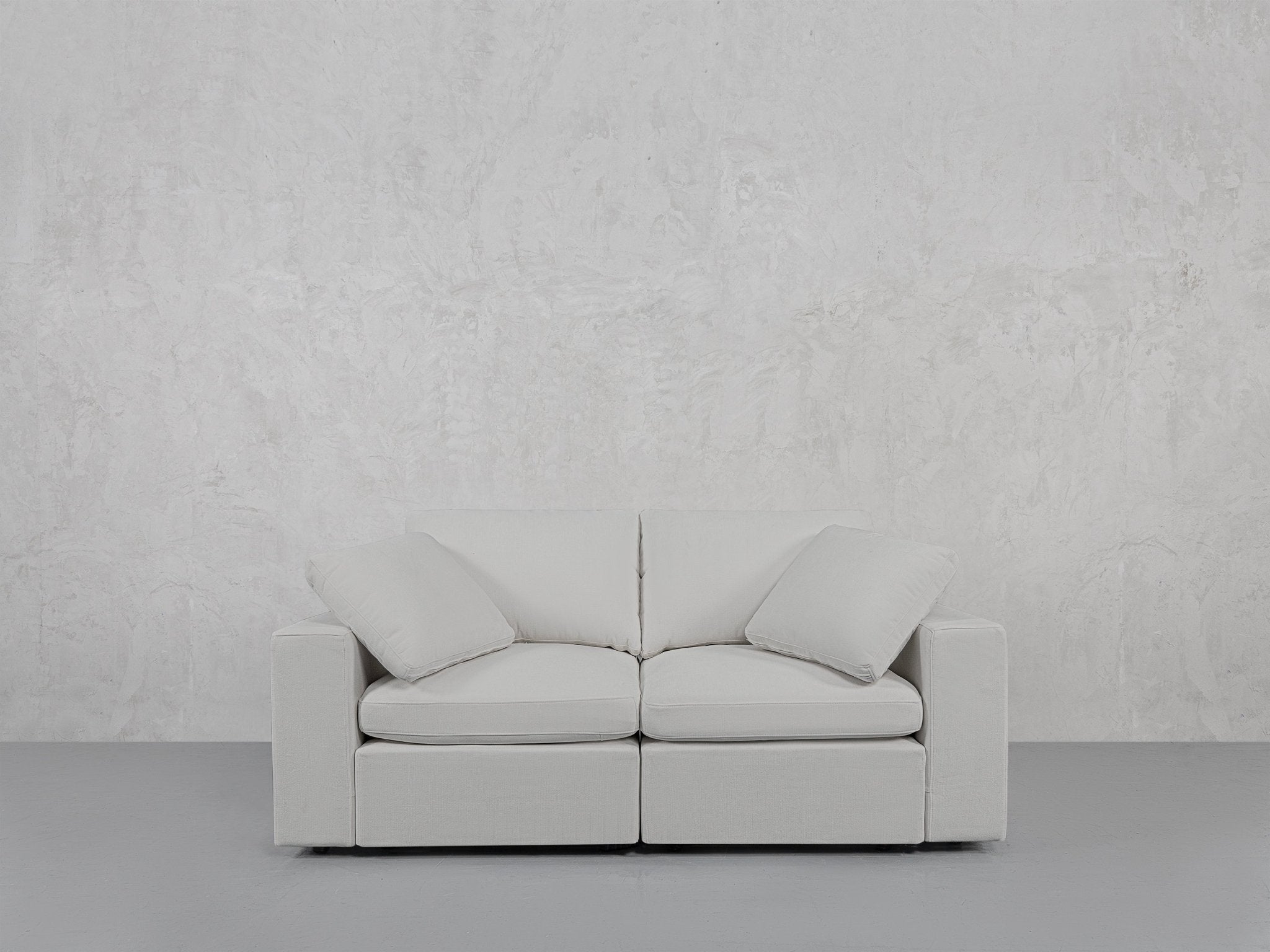White loveseat against grey background