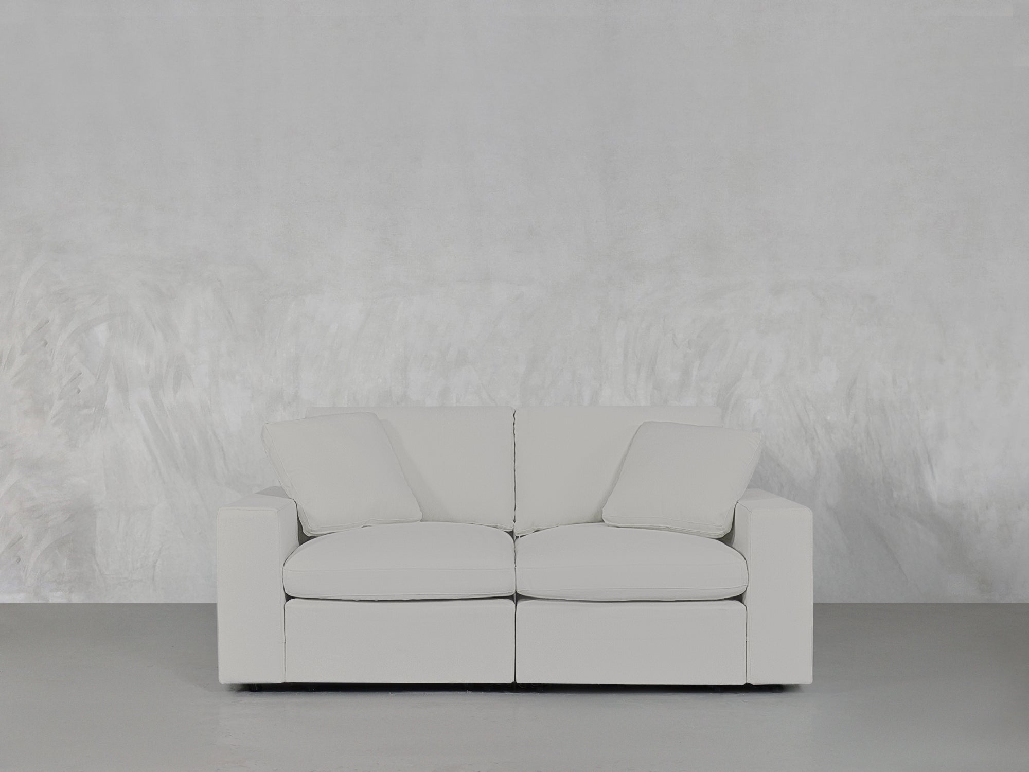 White loveseat on grey floor