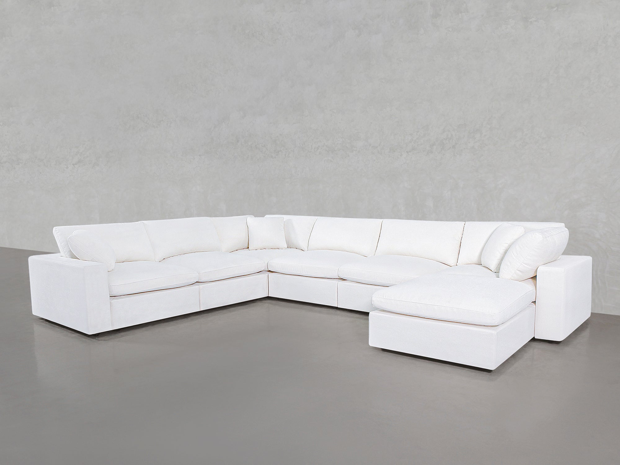 White sectional sofa with chaise on the right, all cushions visible