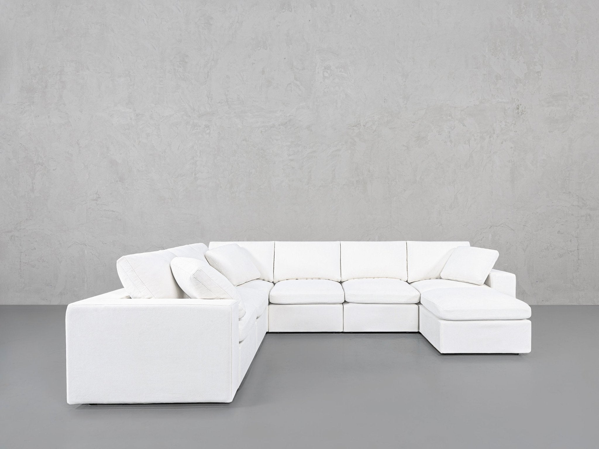White sectional sofa with left armrest and right chaise, spaced evenly
