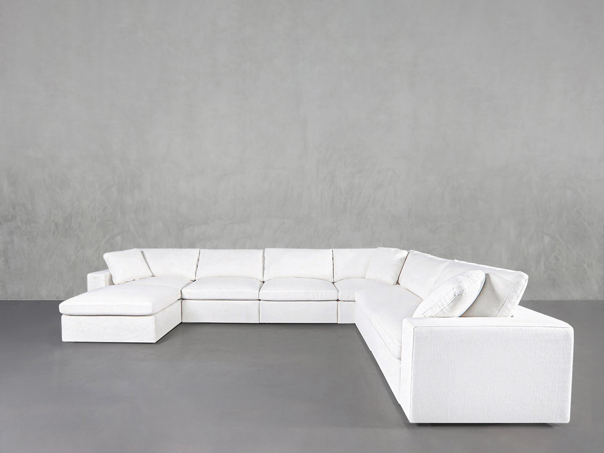 White sectional sofa in a long, low-profile arrangement with a corner unit
